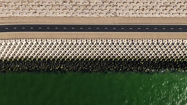 High-angle drone footage showing a coastal road and sea defenses at the Breezanddijk, Netherlands
