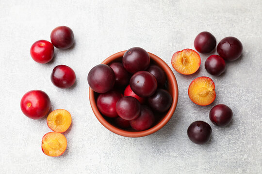 Ripe cherry plums on light grey table, flat lay
