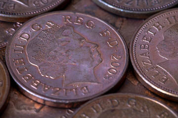 British pennies and two pence featuring Queen Elizabeth II profile portrait. British copper coins. Great Britain national currency. © Sergii