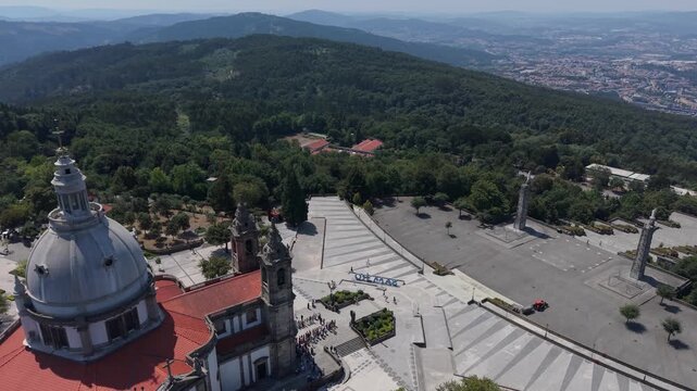Aerial - Close pass over the Sameiro Sanctuary dome bell towers and esplanade steps in Braga