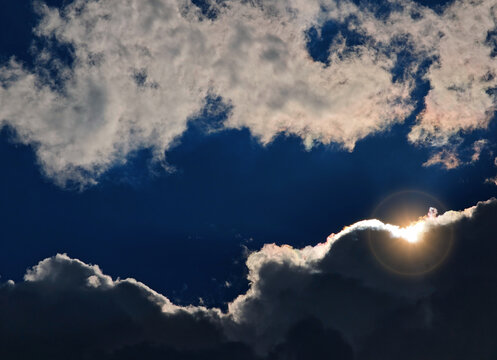 Dramatic sun flare glowing through the clouds