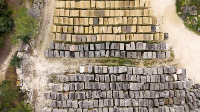 Aerial view of large stone blocks stacked in rows at an outdoor quarry site
