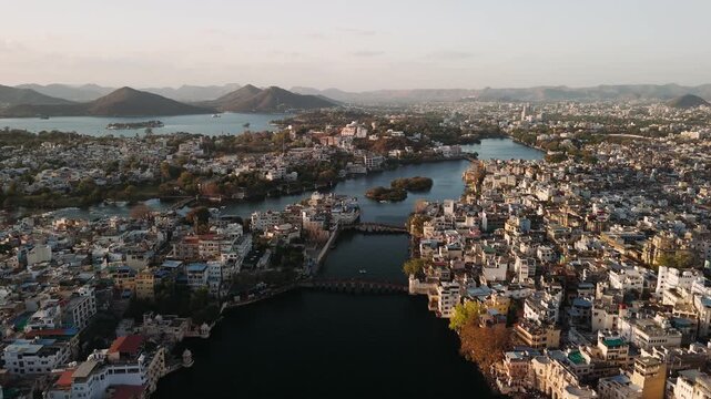 Aerial view of udaipur cityscape with lake pichola and historic buildings during a golden hour sunset in rajasthan, india