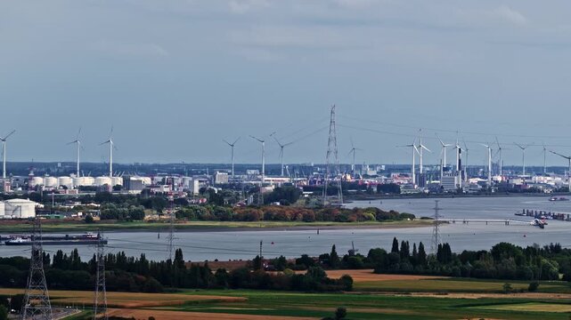 Aerial view of Doel Nuclear Power Plant with wind turbines and industrial storage tanks along the Scheldt river in Beveren-Kruibeke-Zwijndrecht, Vlaanderen, Belgium.