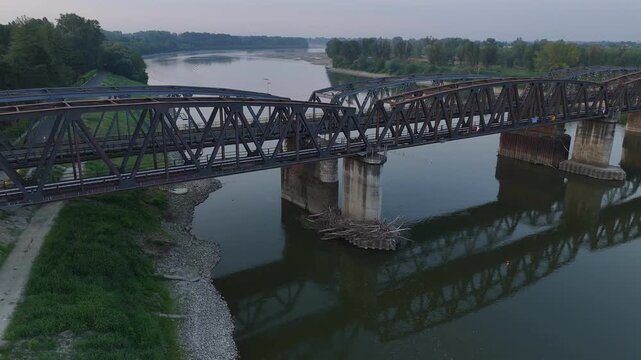 Po River shows exposed gravel beaches, debris and low water beneath the Cremona Po Bridge in Cremona, Lombardy, Italy, Europe, drone descent