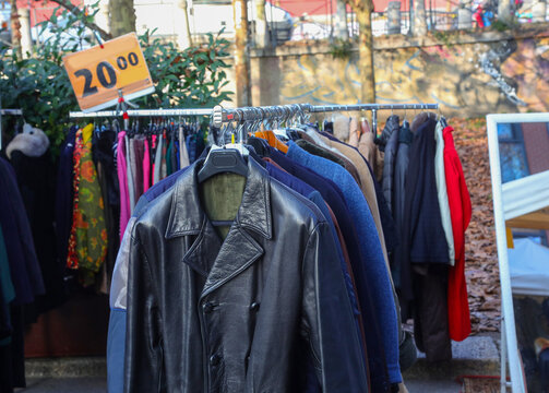 Vintage leather jackets and winter coats on display at an outdoor flea market i