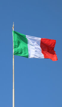 Italian national flag waving on flagpole against clear blue sky in Bergamo Italy