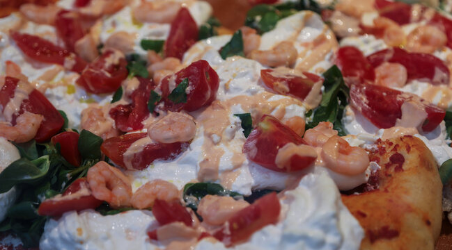 Gourmet Italian pinsa flatbread topped with shrimp burrata cheese and fresh tomatoes