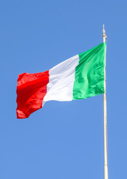 Italian national flag waving in the wind against a clear blue sky in Italy