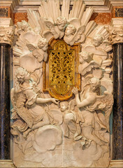 Naklejka premium LUCCA, ITALY - JUNE 23, 2026: The marble tabernacle (Reliquia del Sangue Preziosissino) in the Cenami chapell in the church Basilica di San Frediano by Giovanni Baratta from 18. cent. 