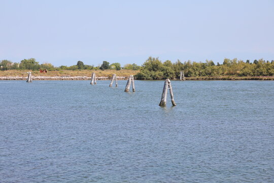 Traditional wooden briccole mooring poles and navigational markers in the Venetian lagoon near Cavallino Treporti Italy