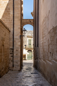 Picturesque street in the historic center of Otranto, with traditional buildings and a relaxed atmosphere reflecting the slow pace of life, Otranto, Salento, Puglia, Italy.