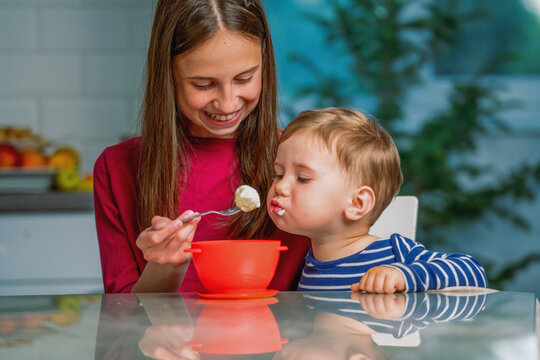 Warm relationship between older sister and younger brother at home.