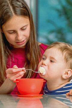 Older sister teaching her little brother healthy eating habits.