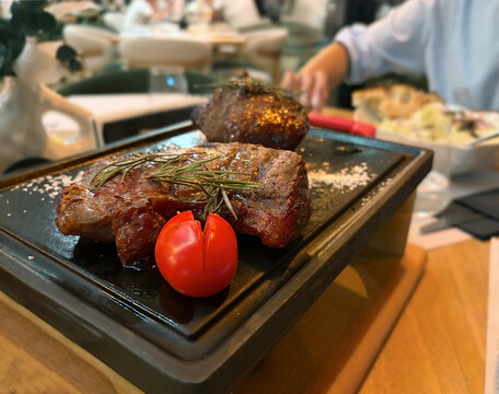 Red meat served on a sizzling hot plate, kept warm and cooking to the desired doneness.
