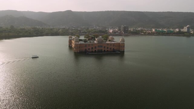 Aerial view of jal mahal water palace on man sagar lake with jaipur cityscape and mountains in the background, india