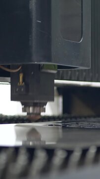 High precision laser tool cuts sheet steel in plant. Sparks show intensity. Concept of advanced manufacturing and industrial accuracy