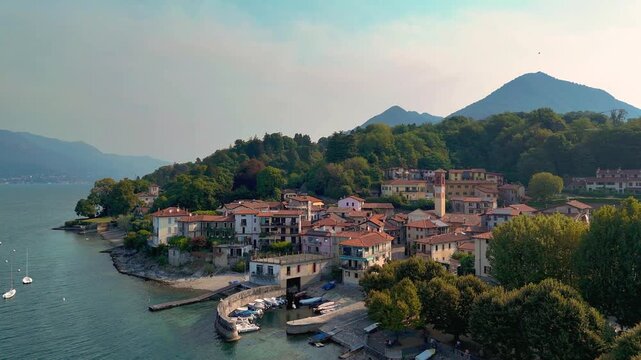 Aerial 4K drone video footage with panoramic view of Cerro on the shores of Lake Maggiore, Italy, capturing the authentic Italian Lakes atmosphere with picturesque waterfront scenery and mountains
