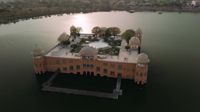 Aerial view of jal mahal water palace in jaipur, india on man sagar lake at sunset with sun reflecting on water