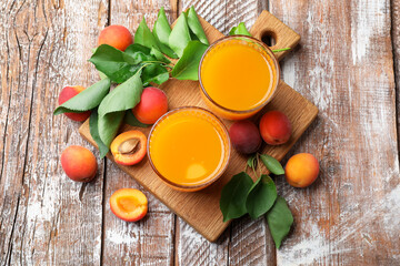 Glass of apricot juice, fresh fruits and leaves on wooden table, top view © New Africa
