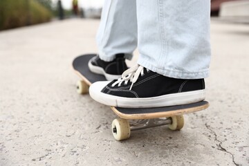 Man riding skateboard on city street, closeup © New Africa