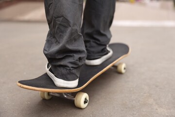 Man riding skateboard on city street, closeup © New Africa