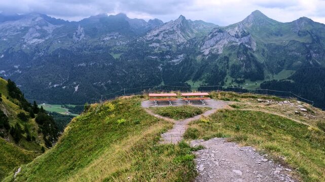 Walking down the famous Stoos ridge trail with panoramic view of the Swiss Alps, Switzerland. 4K cinematic slow motion