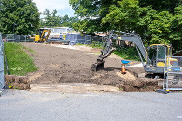 excavator parked at a dirt construction site © Maxwell