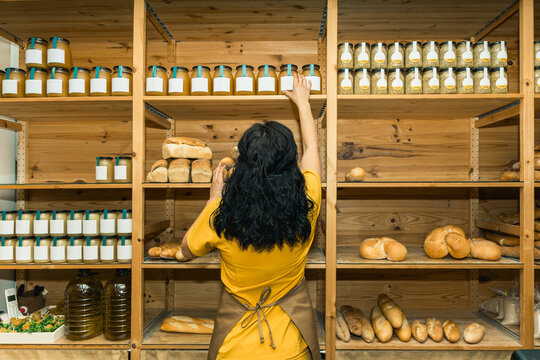 Woman organizing shelves in organic food store