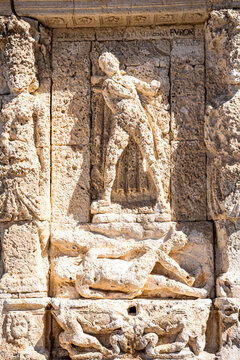 Weathered bas-reliefs and caryatids on the historic Greek Fountain in Gallipoli, a Renaissance-era monument carved in local stone, Salento, Puglia, Italy.