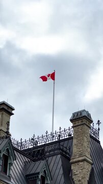 parliament building , Canadian flag,Close up of Canadian flag waving in the wind with a clear blue sky background. Flag blowing in the breeze