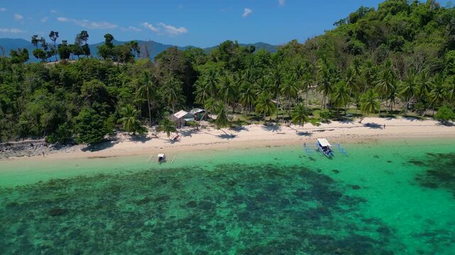 speed ramp time lapse White sandy beach with palm trees and a traditional Filipino outrigger boat on turquoise ocean water, perfect for summer travel. Nice aerial view fly reverse drone panorama