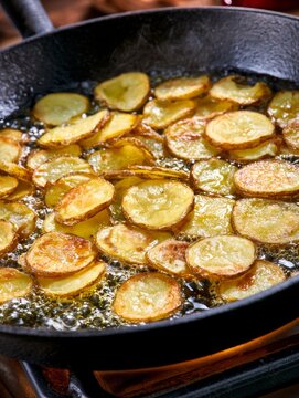 Potato chips frying in hot oil creating crispy snack
