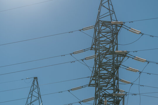 Highvoltage transmission tower stands tall against a clear blue sky during the day