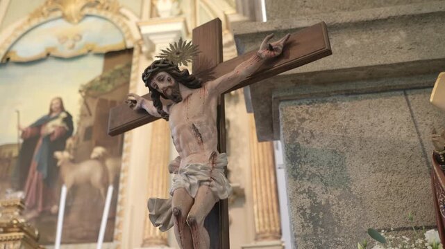 Polychrome Christ on the cross with gold halo and crown of thorns in a church