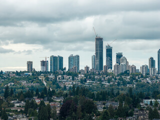 Fototapeta premium Overcast City Skyline With High-Rise Construction Cranes in Burnaby, Greater Vancouver, British Columbia