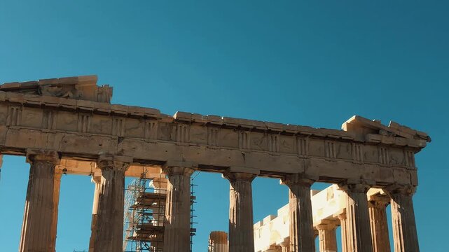Crowds of diverse tourists explore the famous ancient Parthenon and Acropolis historic temple monuments under a clear blue sky during a sunny summer vacation in beautiful Athens, Greece.

