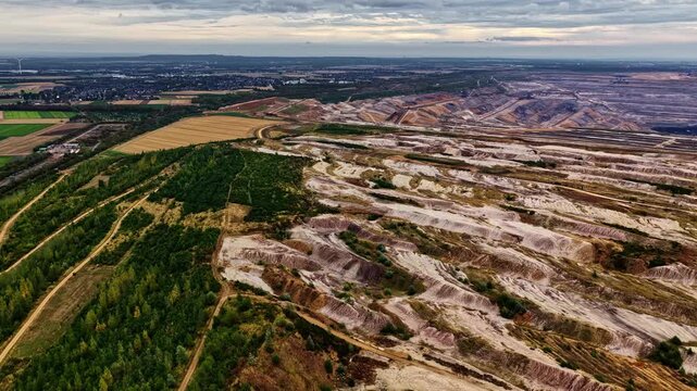 Aerial view of the vast Tagebau Hambach open-pit mine showing deep excavation layers, surrounding forests, and industrial landscape in Elsdorf, Nordrhein-Westfalen, Germany.