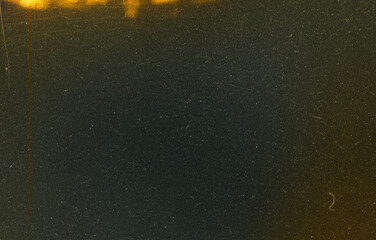 Dark Film Grain Texture with Golden Film Burn, Heavy Dust, and Vertical Edge Scratches on Black Background © dileepa