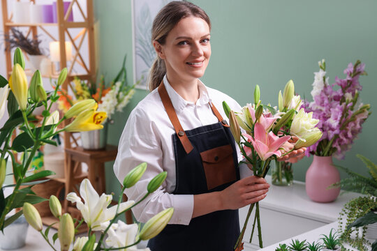 Florist with bouquet of beautiful lilies in shop