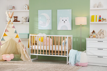 Cute baby room interior with comfortable crib, wigwam and other toys © New Africa
