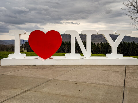 I Love NY Sign Sculpture with Mountain Views on Cloudy Day