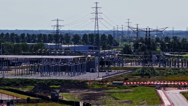 Aerial view of the Google Westpoort Data Center construction site featuring electrical substations, high-voltage power lines, and pylons in Groningen, Netherlands.