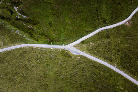 Aerial View of Rural Dirt Road Intersection Crossing Green Meadow Landscape