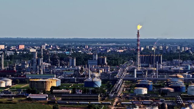 Aerial view of Orlen Plock Production Plant with storage tanks, industrial pipelines, and tall chimneys with flares in Plock, Mazowieckie, Poland.
