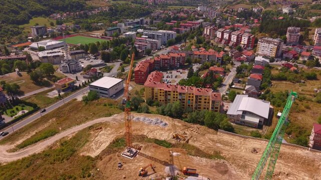 Aerial View of Construction Site with Two Tower Cranes Moving Towards Town Center in Vogosca Bosnia and Herzegovina