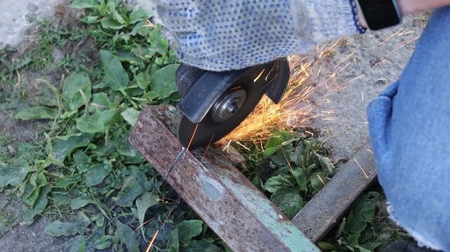 Making sparks while cutting wood in outdoor space