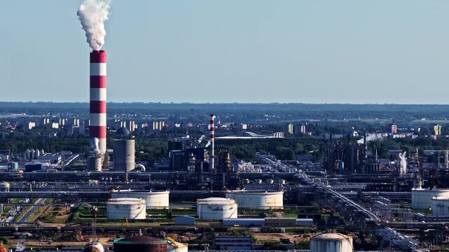 Aerial view of Orlen Plock Production Plant with tall red and white striped chimneys, storage tanks, and industrial infrastructure Plock, Mazowieckie, Poland.