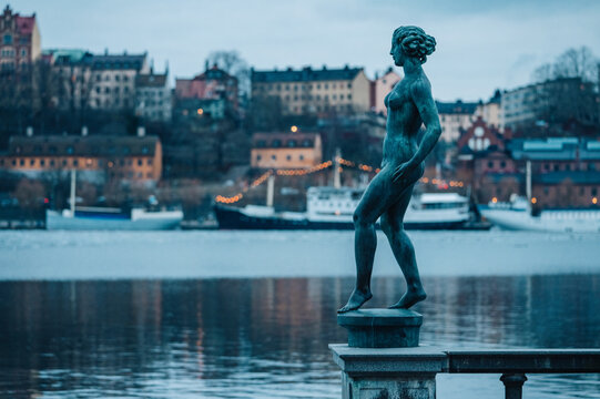 Bronze statue of a woman overlooking the Stockholm waterfront on a cold winter day