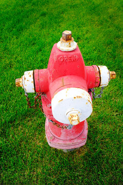 Red and White Fire Hydrant Installed on Green Grass Lawn for Emergency Service for Fire Firemen